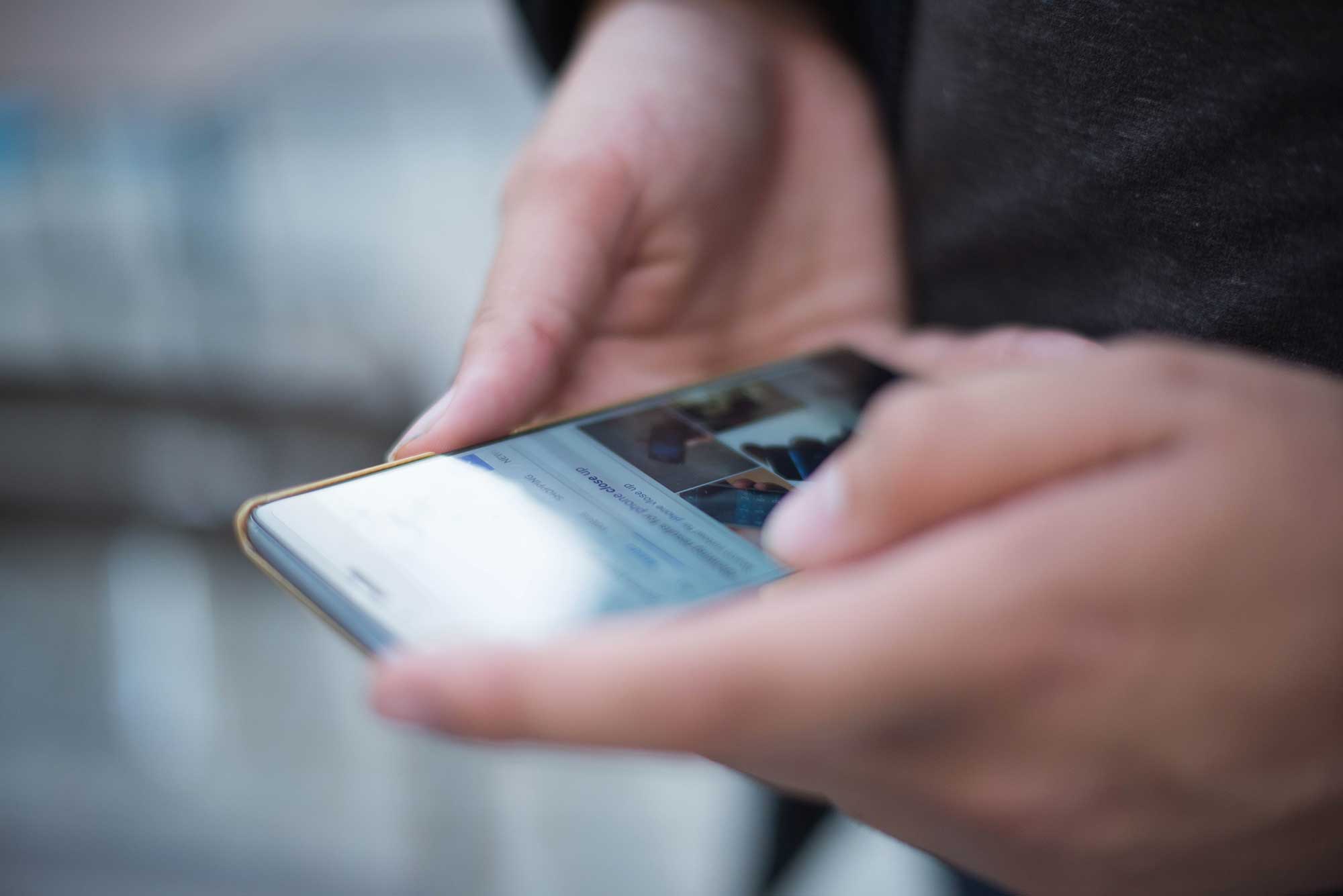Hænder og en mobil tæt på